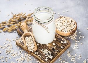 Jar of oat milk with oat flakes.