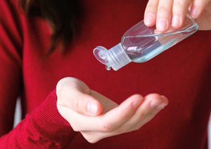 Girl in red t-shirt pouring homemade sanitizer in her hands.