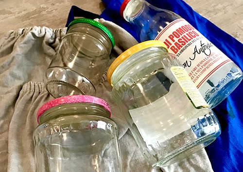 Glass jars and fabric bags laying on a table.