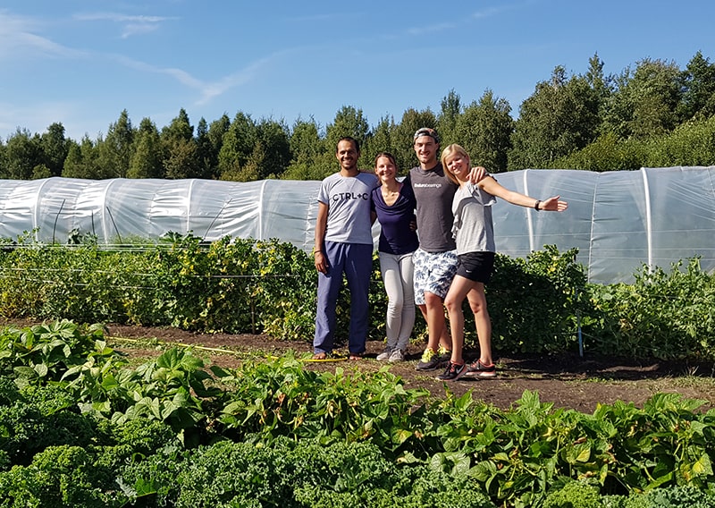 Heartmade family standing in front of the greenhouse of the eco-farm.