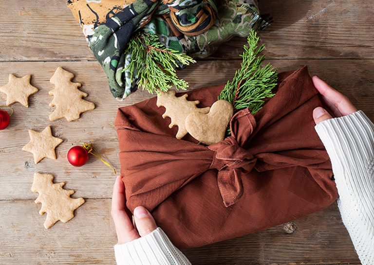 Hands offering a zero waste christmas gift with decoration.